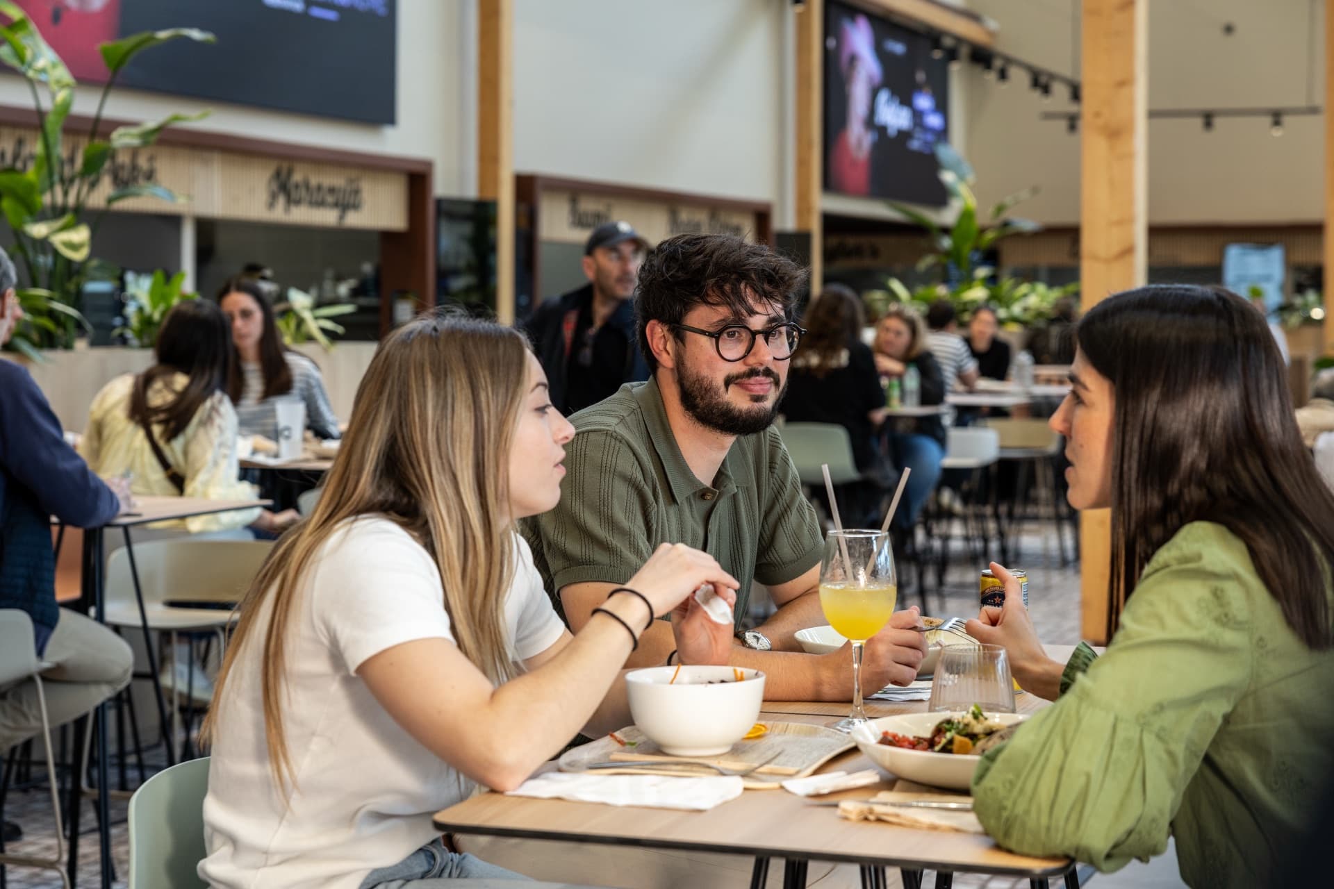 Trois personnes déjeunent au food court du PIC