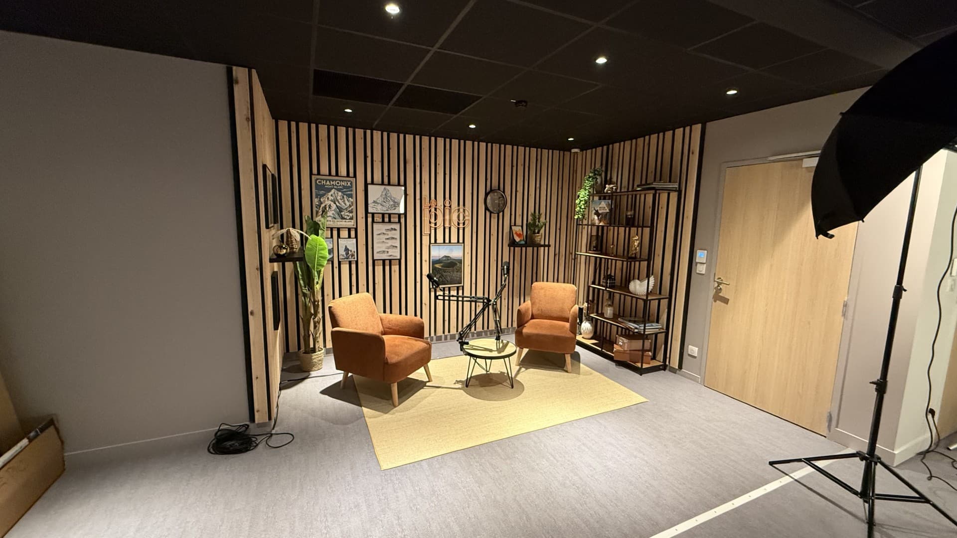 Le plateau du Studio du PIC, deux fauteuils face à face, micros sur perche et mur en tasseaux de bois